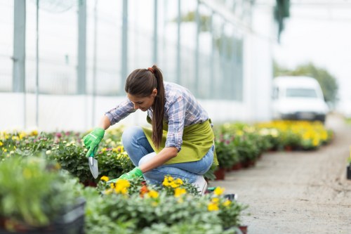 Gardener working in an accessible Manor Park garden, showing pathways and tools